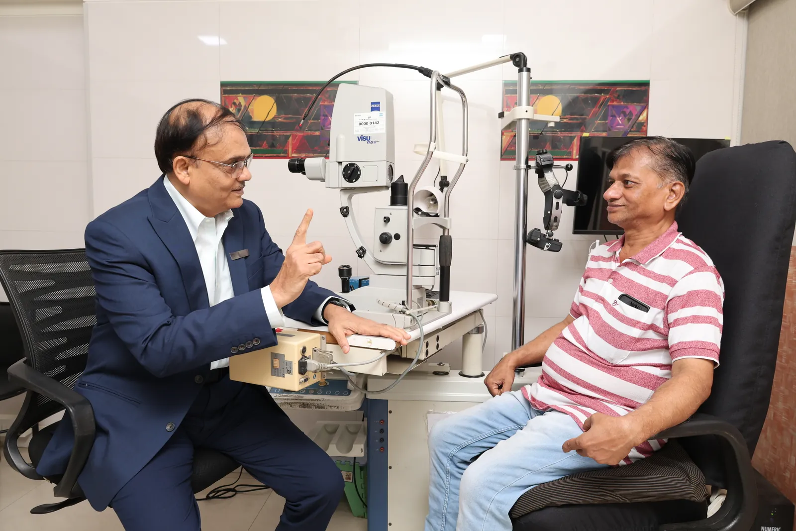 Dr. Nitin R. Malkan explaining an eye examination to a patient at Akshar Eye Clinic, Malad West