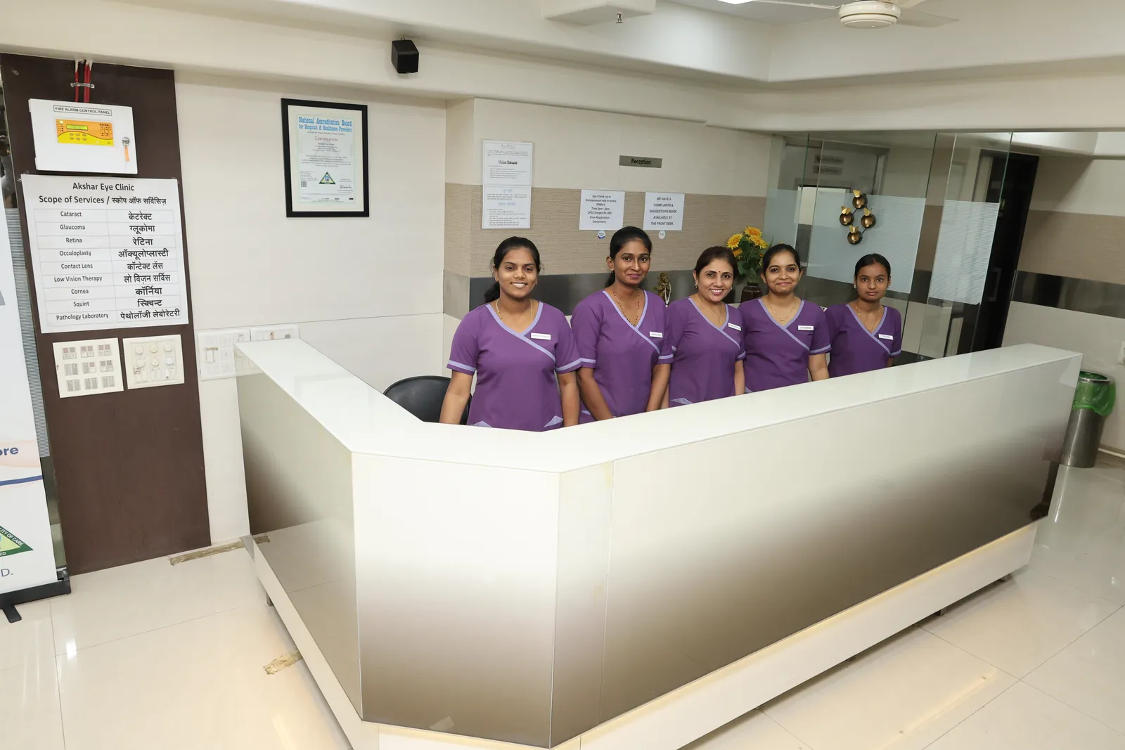 The reception desk at Akshar Eye Clinic, with five team members standing behind it